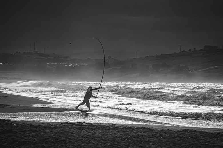un pêcheur à la ligne sur la plage